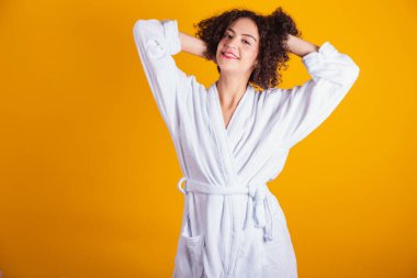 Beyaz bornozlu beyaz bir model. Eller saçta..