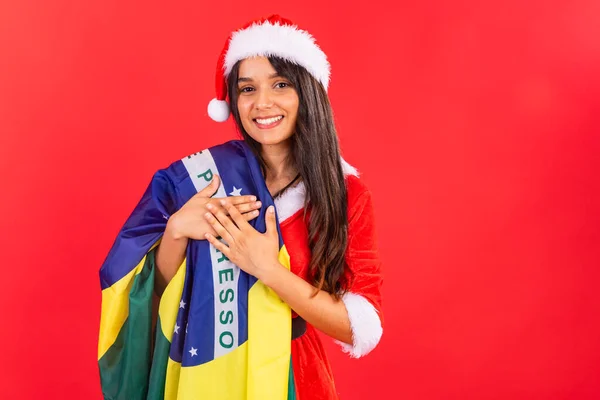 Brazilian woman, teenager, wearing Christmas clothes, with the Brazilian flag.