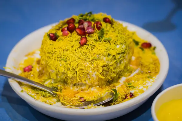 Dahi Vada Chaat, Sev, nar tohumu ve diğer baharatlarla süslenmiş bir tabakta servis edildi. Popüler bir Kuzey Hindistan atıştırmalığı..