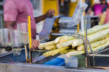 Hindistan 'da yaz mevsiminde tatlı meyve suyu sattığı için yol kenarında şeker kamışı suyu tezgahı var. Bu çok popüler bir içecek ve birçok sağlık sigortası var..
