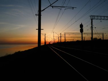 Demiryolunun silueti günbatımının ve bulutların arkaplanına karşı