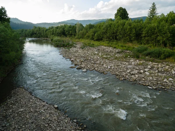 Prut Nehri kayalık kıyılar ve ormanlar arasında fırtınalı bir derede akar. Ufuktaki Karpatlar