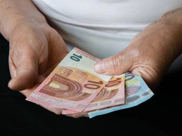 小さなユーロ紙幣を持っている老婦人の手 正面図 ロイヤリティフリーのストック写真