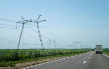 Otoyol kenarındaki bir alanda yüksek voltajlı elektrik hatları