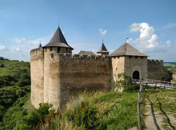 Ortaçağ kalesi, yüksek duvarlar ve kapının önünde bir köprü.
