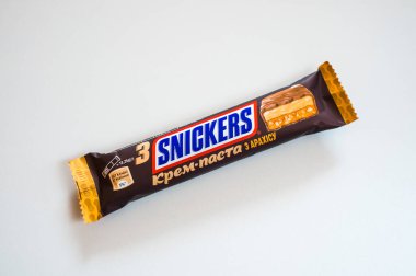 Zaporizhzhia, Ukraine - July 5, 2023: Chocolate bar Snickers Peanut cream paste on a white background