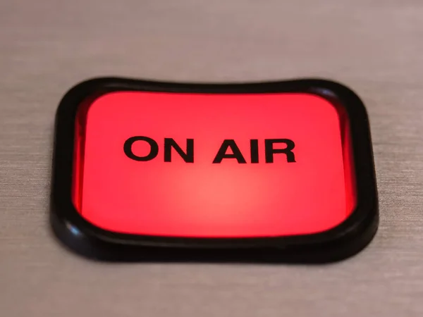 放送スタジオのデジタルコンソール上の明るい赤いOn Airボタンのクローズアップ ロイヤリティフリーのストック画像