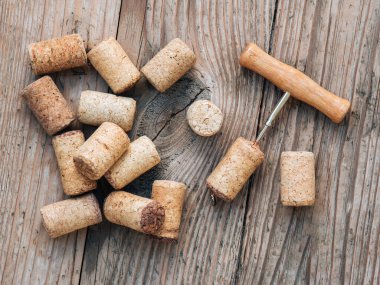 Şarap mantarları ve eski ahşap masa üzerindeki tirbuşon manzarası.