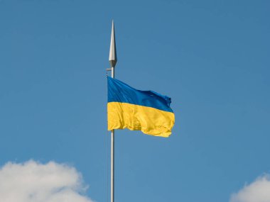 Ukrayna 'nın ulusal bayrağı rüzgarda dalgalanıyor gökyüzünün arka planına ve bulutlara karşı yüksek bir bayrak direğinde