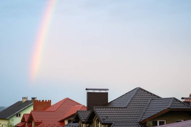 Evlerin çatılarının üzerinde gökkuşağı var. Arkaplan