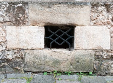 Büyük kireçtaşı bloklardan yapılmış antik taş duvar döşeme demirleri ile korunan bir koğuş penceresi var.