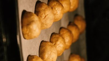 Yuvarlak ev yapımı kurabiyeler fırında pişirilir ve boyutu artar. Dikey video