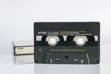 Zaporizhzhia, Ukraine - December 23, 2023: Audio cassette TDK SA100 Super Avilyn 100 minutes on a white background with reflection clipart