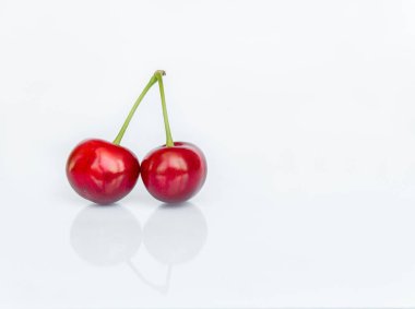Bir çift tatlı kiraz meyvesi (Prunus avium) yakın plan beyaz zemin üzerinde yansıması ile izole
