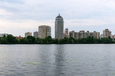 Kyiv, Ukrayna - 16 Haziran 2024: Dinyeper nehrinin kıyısında bulutlu bir havada Obolon bölgesi