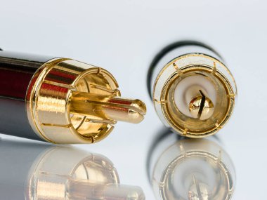 İşitsel altın kaplamalı RCA bağlantı ipuçlarının beyaz arkaplandaki yansıma ile izole edilmiş makro fotoğrafı