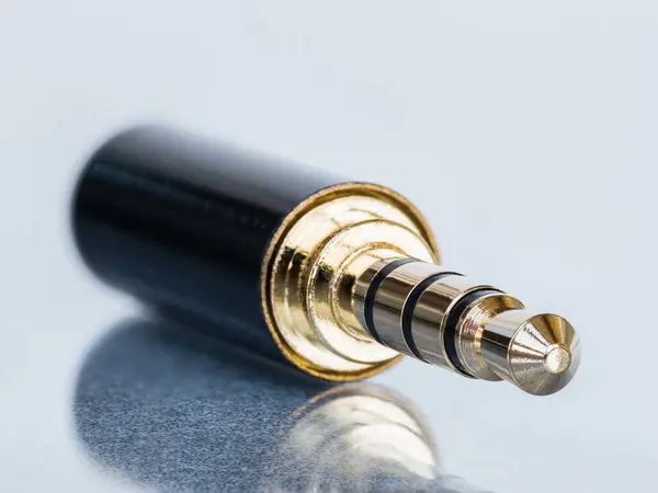 Beyaz arkaplanda yansıma ile izole edilmiş 4 adet altın kaplama mini vale konnektörü makro çekimi