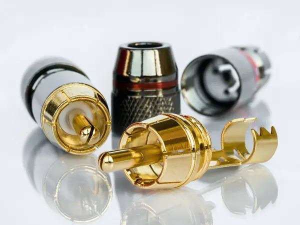 Parçalanmış sesli-altın kaplamalı RCA bağlantısının makro fotoğrafı beyaz arkaplanda yansıma ile izole edildi