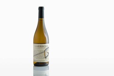 Zaporizhzhia, Ukrayna - 11 Ocak 2024: Bir şişe yarı tatlı beyaz şarap Garrigue Vin de la Communaute Europeenne yansıması ile beyaz arka planda izole edildi
