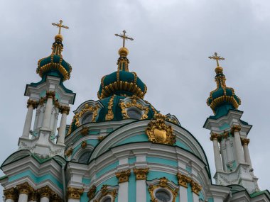 Kyiv, Ukrayna - 7 Nisan 2025: 18. yüzyılda Bartolomeo Rastrelli tarafından tasarlanmış bir Barok başyapıtı olan Ukrayna 'nın Kyiv kentindeki Aziz Andrew Kilisesi' nin yaldızlı kubbeleri ve süslü haçları