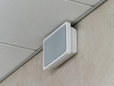 Acil durum ve yangın alarmı hoparlörü asılmış tavanın altındaki duvara monte edildi.