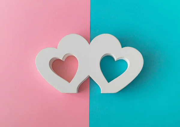 Heart wood frame on pastel pink and blue background. Creative love minimal concept. Flat lay design.