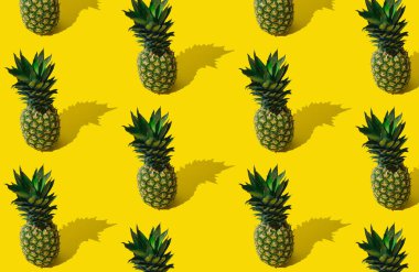 Açık sarı arka planda ananasla yapılmış taze tropik yaz meyveleri. Moda minimal ananas desen düzeni. Doğal egzotik yaz yemekleri konsepti. Ananas estetiği..