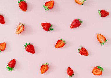 Açık renkli pembe arka planda taze ve sağlıklı çileklerden yapılmış moda meyve deseni. Yaratıcı asgari çilek desenli kompozisyon. Doğa yiyecekleri konsepti. Süslü pembe arka plan düzlüğü.