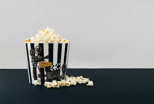Creative layout made of popcorn bucket full of popcorn on black and white background. Minimal movie concept. Trendy popcorn and movie idea. Popcorn aesthetic.