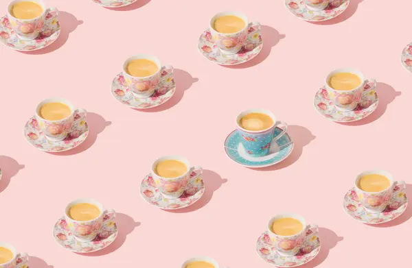Trendy pattern made of floral cup of coffee on light pastel peachy pink background. Minimal concept. Creative coffee pattern idea. Fancy peachy pink background. Coffee aesthetic.