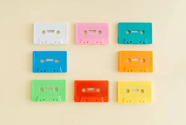 Layout of retro colorful audio cassette tapes on pastel beige background. Creative concept of retro technology. 80's aesthetic. Vintage audio cassette tape idea. Retro nostalgia. Flat lay. Copy space.