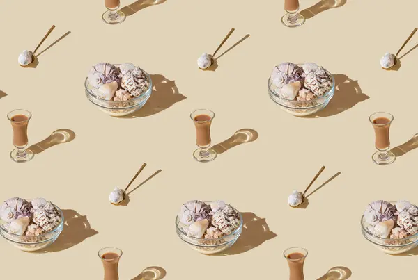 Summer pattern composition made with glass bowl full of sea shells, cream liqueur drink and golden spoon on bright beige background. Minimal concept. Summertime food and drink idea. Summer aesthetic.