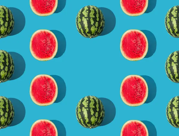 Trendy fruit pattern composition made with ripe and fresh watermelon on blue background. Minimal summer food concept. Creative summer pattern background with copy space idea. Watermelon aesthetic.