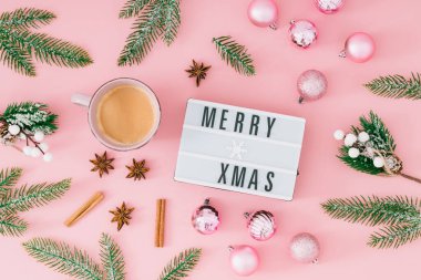 Yeşil Noel ağacı dallarından yapılmış Noel şablonu, pembe arka planda bir fincan kahveli pembe Xmas mücevherleri. Minimum Noel ve Yeni Yıl konsepti. Yaratıcı bayram arkaplanı.