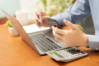 Bir bireyin eli cep telefonu, kredi kartı ve not defterini ustalıkla kullanıyor ve online alışveriş dünyasına kusursuz bir şekilde giriyor. Ekranda bir parmak ucuyla, dijital bir pazar yeri.