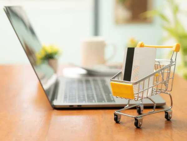 stock image Shopping online with small shopping cart and credit card offers convenient and efficient way to purchase limited number of items, allowing for easy browsing, secure transactions,and seamless checkout.