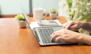 Meşgul işadamı işini becerikli bir şekilde dizüstü bilgisayarını, cep telefonunu ve hesap makinesini kullanarak yönetir, görevler ve hesap makineleri arasında sorunsuzca geçiş yapar,