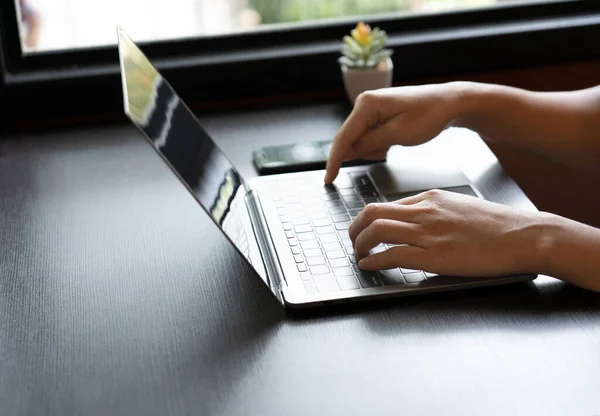 stock image focused businessman sat at the elegant wooden table, his skilled hand swiftly tapping away on the sleek laptop keyboard, engrossed in his work. determined expression mirrored his dedication. close up.