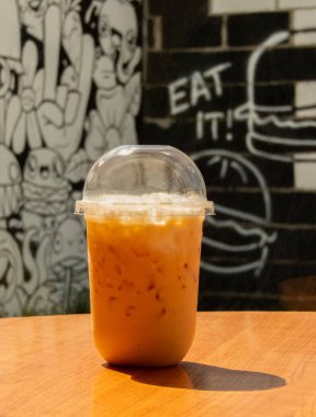 Masadaki Tayland çayı Tayland 'ın eşsiz lezzetlerini yakalayan lezzetli ve ferahlatıcı bir içecektir. Canlı turuncu rengi ve kremsi dokusu onu karşı konulmaz yapıyor. Tayland çayı. .