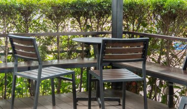 Balkondaki ahşap sandalye, sağlam inşaatı ve kırsal cazibesiyle, sizi gevşemeye ve gevşemeye davet ediyor, rahat koltuğu açık havanın dinginliğine bırakıyor ve hafif esintinin tadını çıkarıyor.