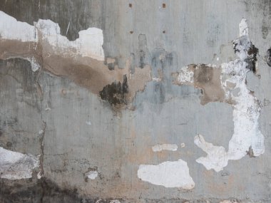 Bir zamanların sağlam beton yüzeyi, zamanla yıpranmış ve ihmal edilmiş, şimdi sayısız yılın izlerini taşıyor. Bir zamanlar pürüzsüz olan yüzü, yıpranmış yüzü boyunca kırışıklıklar gibi uzanan derin çatlaklarla gölgelenir.. 