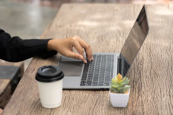 busy businesswoman\'s skilled hand deftly juggled sleek tablet, a steaming cup coffee, and buzzing mobile phone, seamlessly multitasking to stay connected, informed, productive in her fast-paced world.