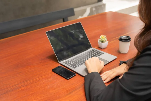 stock image business woman sitting at desk with professional expression sitting at work with a tablet in hand occasional sip of coffee and manage mobile phones attentively. efficiently juggling her tasks staying.