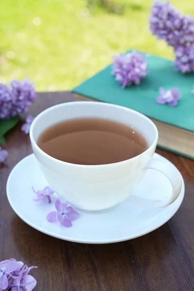 Egy Csésze Orgona Tea Egy Asztalon Egy Régi Könyvvel Egy — Stock Fotó