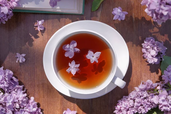 Egy Csésze Orgona Tea Egy Asztalon Egy Régi Könyvvel Egy — Stock Fotó