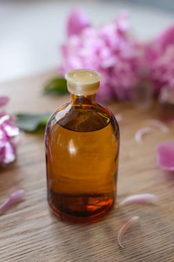 Küçük bir şişe şakayık tentürü (su aşılama, özüt, parfüm). Şakayık özü tentürü. Parfüm ve kozmetik ürünleri için güzel kokulu bir çiçek. Yan görünüm, metin için boşluk kopyala, çarpım yeri.