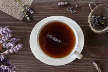 Lavanta çayı ve taze lavanta çiçekleriyle dolu bir fincan. Üst manzara, düz uzanma