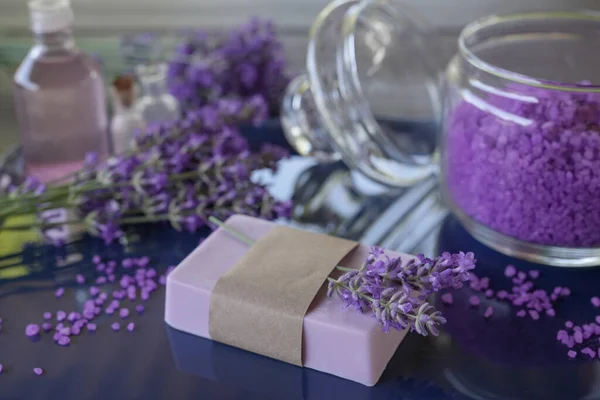 Lavender Spa products and lavender flowers on a table. Handmade soap, essential oil and lavender bath salt - beauty treatment. Healthy skin care. SPA concept. Side view, copy space for text.