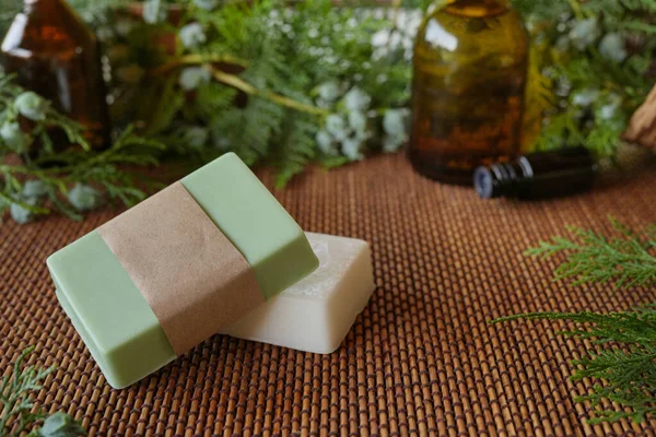 Natural handmade soap on a wooden background. Spa-natural treatments. Natural organic soap from scratch with pine aroma, essential oils. Seasonal pine handmade soap. Side view, copy space for text.