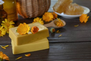 Calendula ile doğal el yapımı sabun (saksı kadife çiçeği). Ev yapımı yüz ve vücut maskesi ya da fırça için doğal malzemeler. Sağlıklı cilt bakımı. SPA konsepti. Seçici odaklanma. Yan görünüm, metin için boşluk kopyala